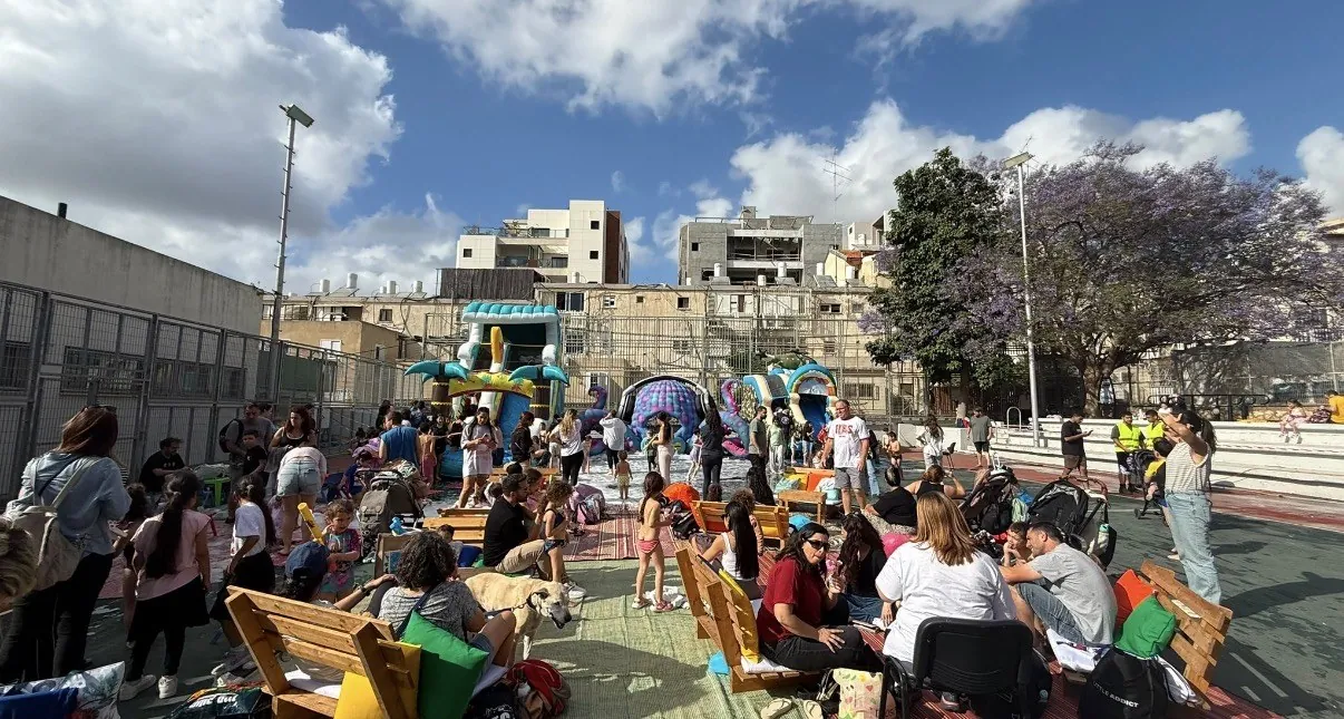 אירוע קהילה — מתקנים מתנפחים, ישיבה ומשפחות ברחבה פתוחה